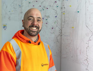 Man smiling in front of board